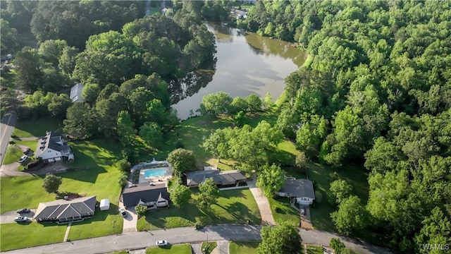 aerial view of property and surrounding area with a nearby body of water and a forest