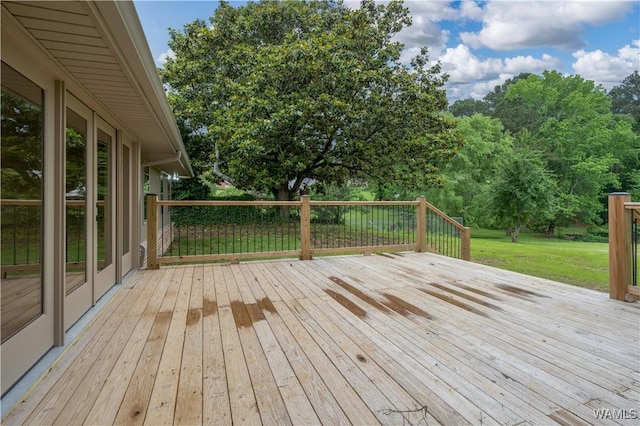 wooden terrace featuring a yard and view of scattered trees