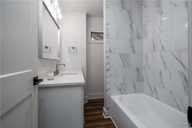 bathroom featuring vanity, wood finished floors, and tub / shower combination