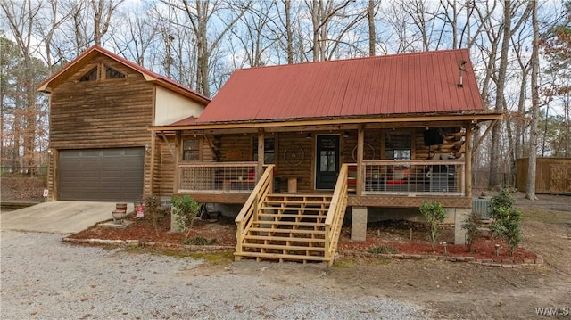 cabin featuring a garage and covered porch