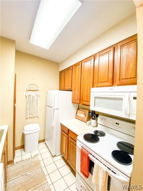 kitchen featuring light tile patterned floors and white appliances