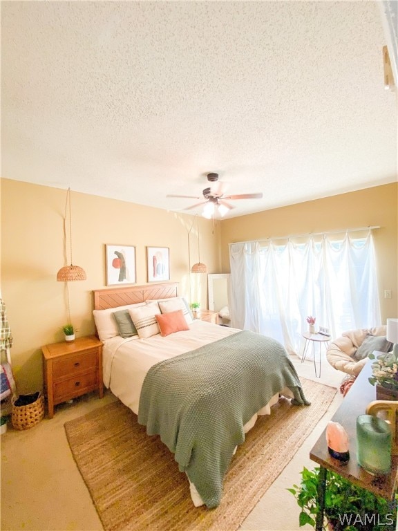 carpeted bedroom with ceiling fan and a textured ceiling