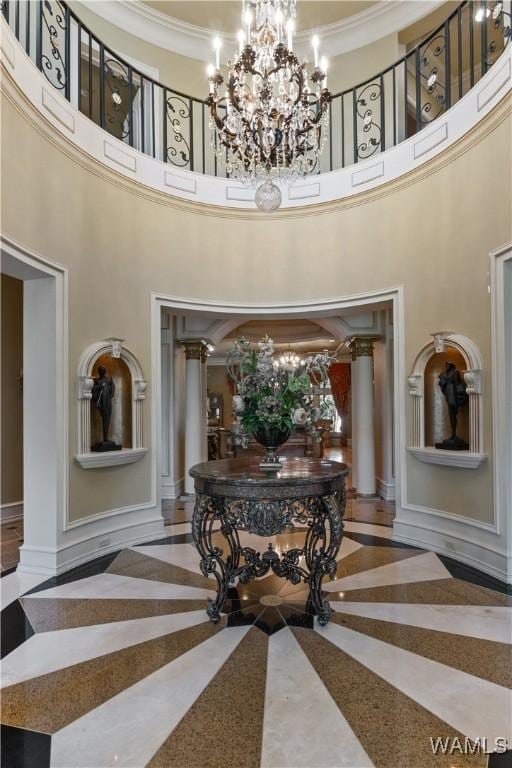 interior space featuring a notable chandelier, a towering ceiling, and crown molding