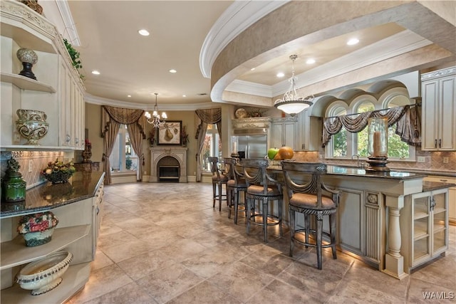 kitchen with backsplash, built in fridge, pendant lighting, and ornamental molding