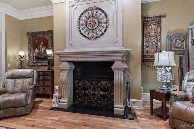 sitting room with a fireplace, wood-type flooring, and ornamental molding