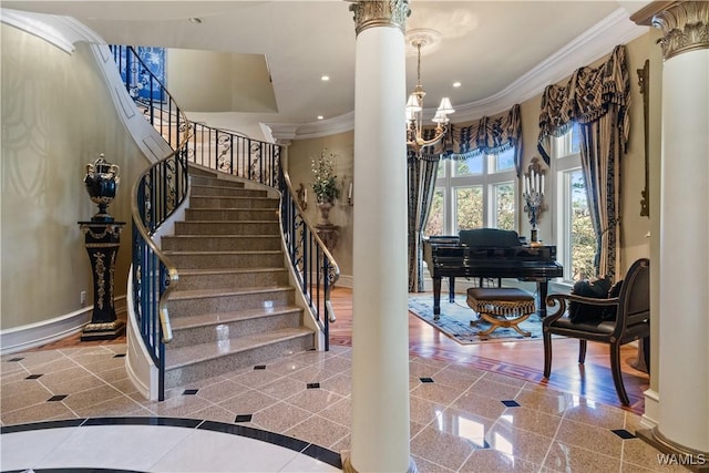 staircase featuring hardwood / wood-style flooring, decorative columns, crown molding, and a notable chandelier