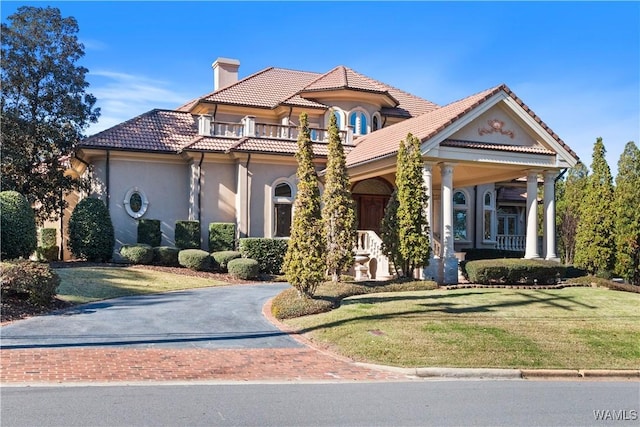 view of front of property with a balcony, a front lawn, and a porch