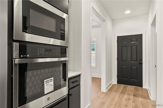 kitchen with light hardwood / wood-style flooring and appliances with stainless steel finishes