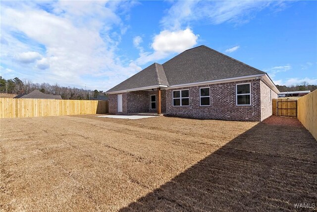 back of property with a yard and a patio area