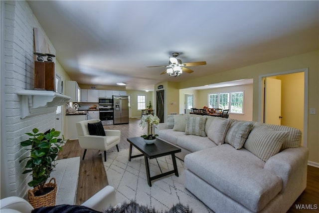 living room featuring ceiling fan and light hardwood / wood-style flooring