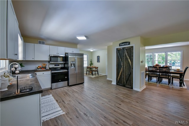 kitchen featuring white cabinets, sink, stainless steel appliances, and light hardwood / wood-style flooring