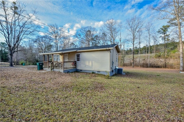 rear view of property with central AC unit, a deck, and a yard