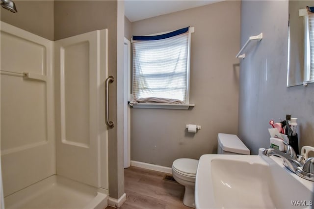 bathroom featuring sink, hardwood / wood-style floors, toilet, and walk in shower