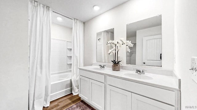 bathroom featuring wood-type flooring, vanity, and shower / tub combo with curtain