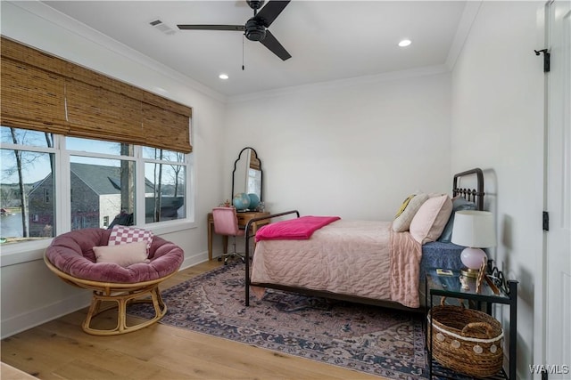 bedroom featuring crown molding, baseboards, and wood finished floors