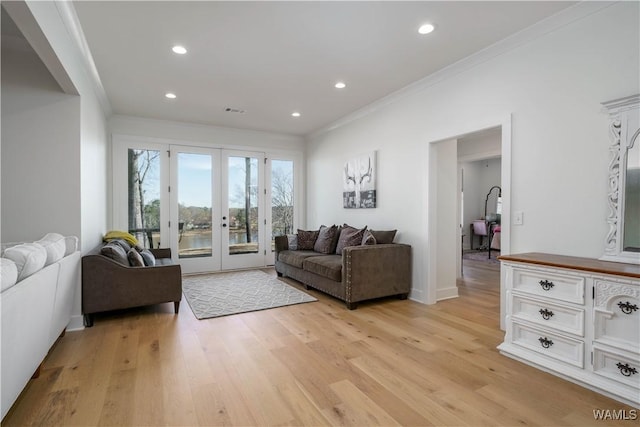 living area with baseboards, recessed lighting, french doors, crown molding, and light wood-type flooring