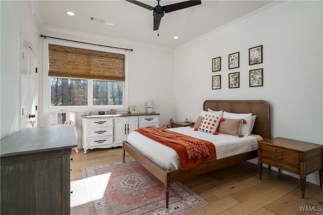 bedroom with light wood-type flooring, visible vents, ornamental molding, and recessed lighting