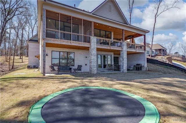 rear view of property with french doors, a patio, and brick siding