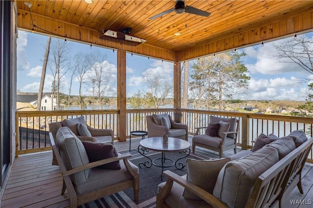 wooden deck featuring an outdoor living space, ceiling fan, and a water view