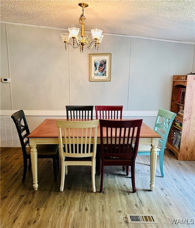 11624 Summer Chase Rd, Mccalla, AL 35111 - dining room featuring a textured ceiling, a chandelier, wood finished floors, and ornamental molding