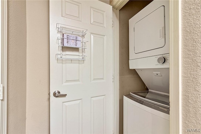 clothes washing area featuring stacked washer / dryer