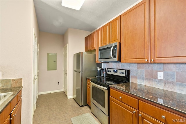 kitchen featuring stainless steel appliances, light tile patterned floors, electric panel, and decorative backsplash