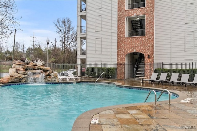 view of swimming pool featuring pool water feature and a patio area