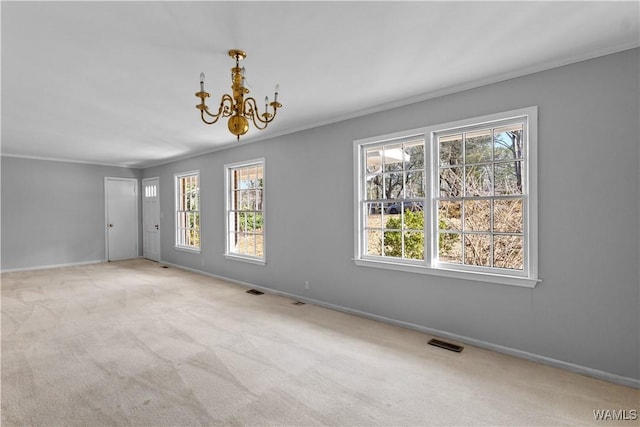 carpeted spare room with an inviting chandelier, crown molding, and a healthy amount of sunlight