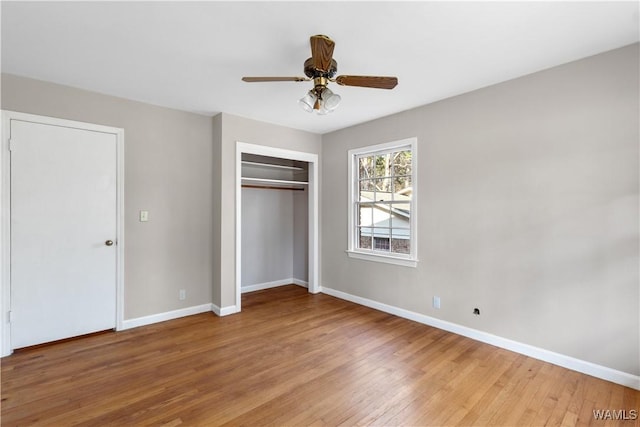 unfurnished bedroom with ceiling fan, light wood-type flooring, and a closet