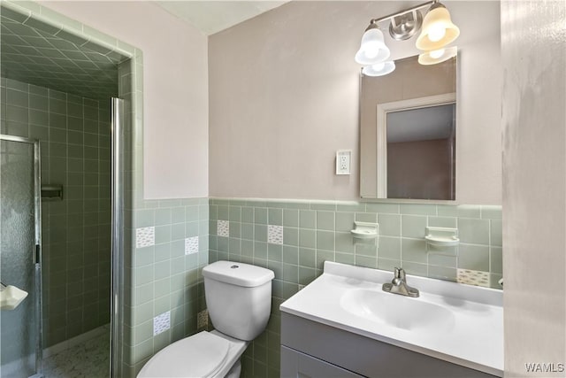 bathroom featuring an enclosed shower, vanity, tile walls, and toilet