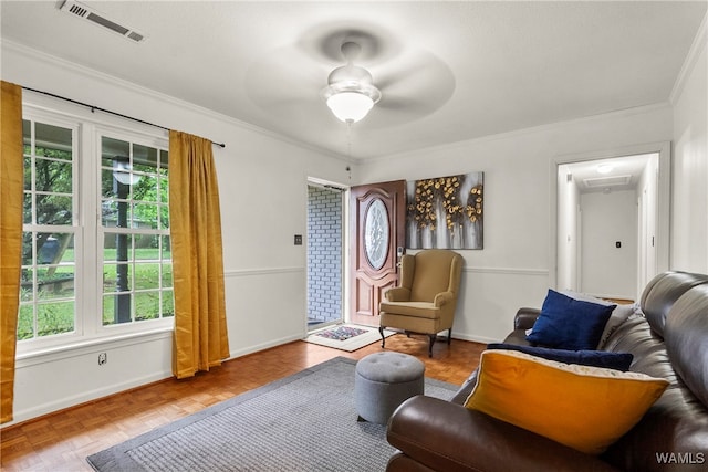 living area featuring ceiling fan, ornamental molding, and parquet flooring