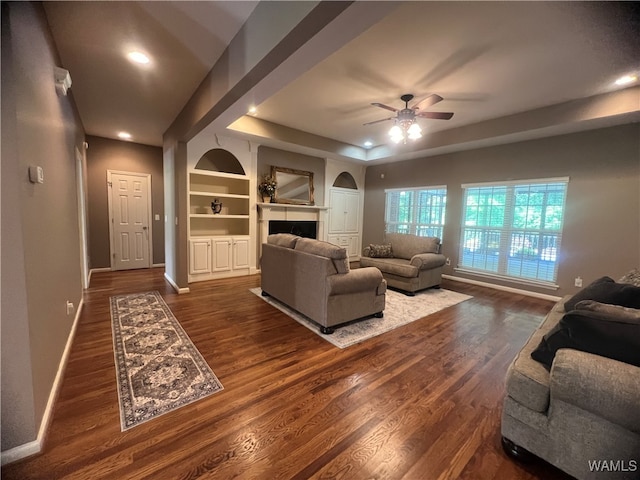 living room featuring ceiling fan and dark hardwood / wood-style flooring