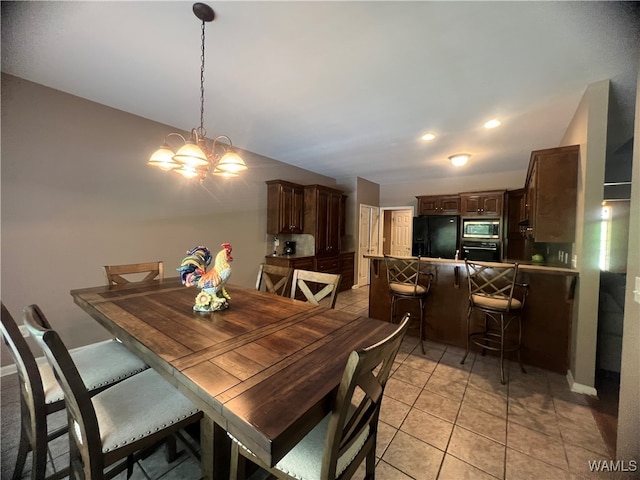 tiled dining room featuring an inviting chandelier