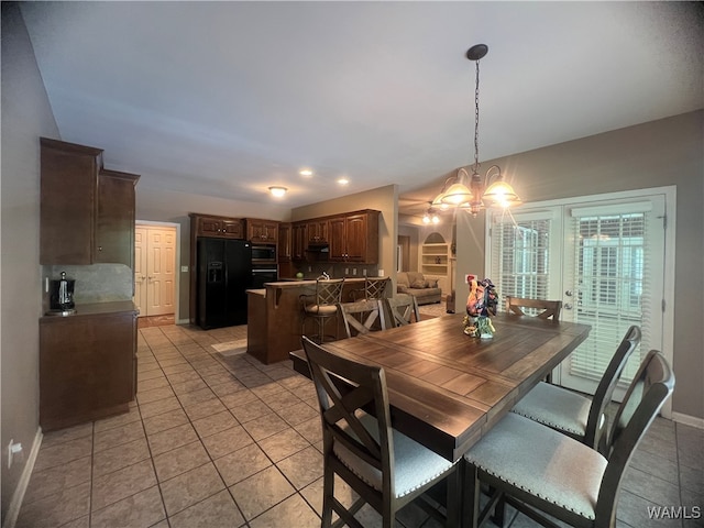 dining space with light tile patterned floors and an inviting chandelier