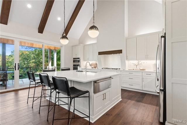 12437 Rising Tide, Northport, AL 35475 - kitchen with hanging light fixtures, an island with sink, appliances with stainless steel finishes, beam ceiling, and white cabinetry