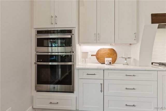 12437 Rising Tide, Northport, AL 35475 - kitchen with tasteful backsplash, white cabinetry, and stainless steel double oven