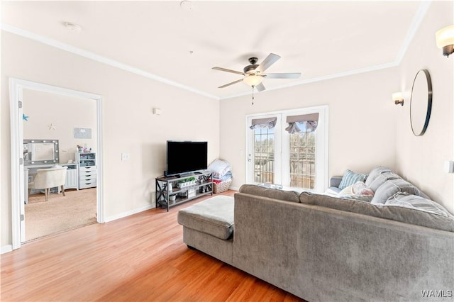 living area featuring baseboards, ceiling fan, ornamental molding, and wood finished floors