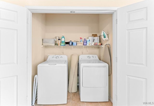 laundry room featuring light tile patterned floors, laundry area, and washer and clothes dryer