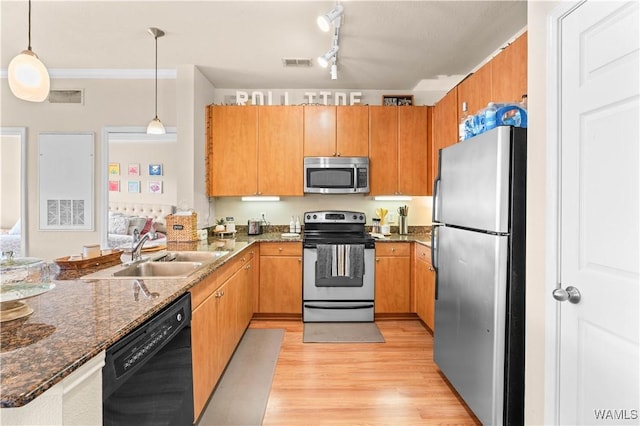 kitchen with visible vents, dark stone counters, appliances with stainless steel finishes, pendant lighting, and a sink