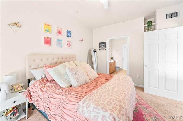 bedroom with light colored carpet, visible vents, and connected bathroom