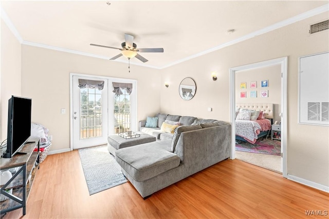 living room with baseboards, visible vents, ceiling fan, ornamental molding, and wood finished floors