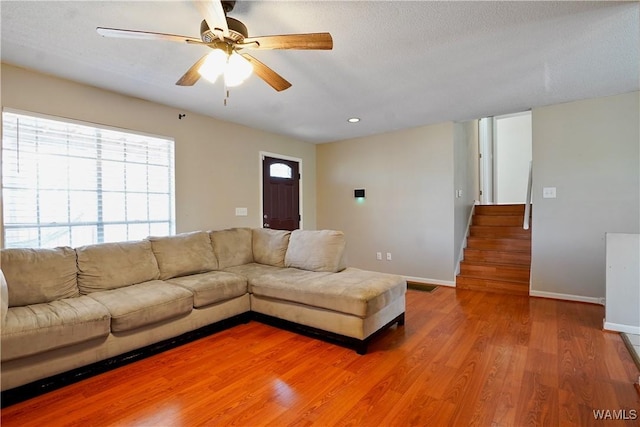 unfurnished living room featuring light wood finished floors, recessed lighting, stairway, ceiling fan, and baseboards