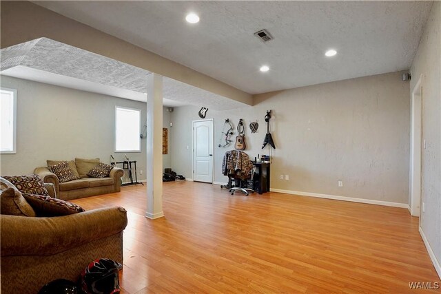 living area with light wood-style floors, baseboards, visible vents, and recessed lighting