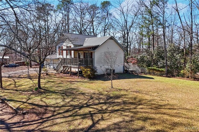 view of side of property with metal roof, stairway, a lawn, and a porch