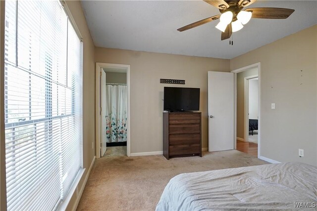 bedroom with light carpet, ceiling fan, and baseboards