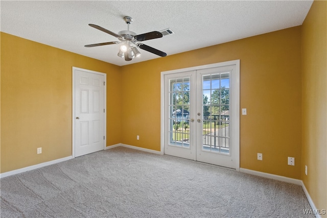 carpeted empty room featuring ceiling fan, french doors, and a textured ceiling