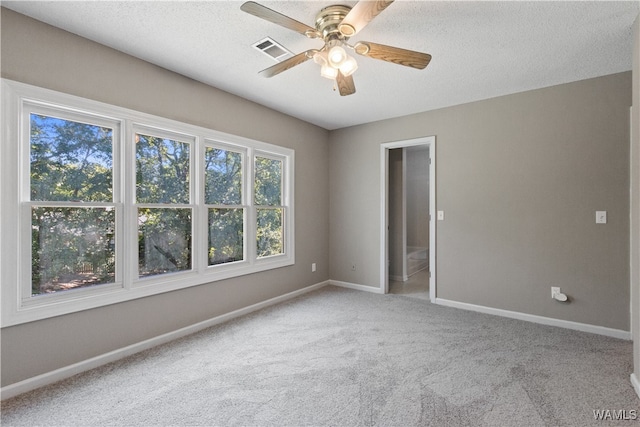 carpeted spare room featuring a textured ceiling and ceiling fan