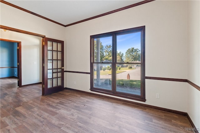 spare room featuring dark hardwood / wood-style flooring, crown molding, and french doors