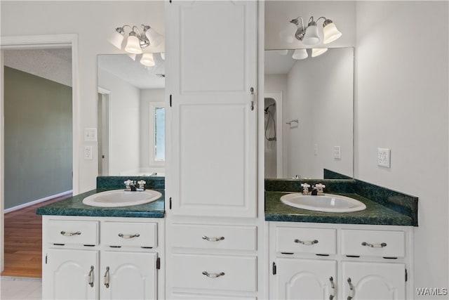 bathroom with vanity, wood-type flooring, and a textured ceiling