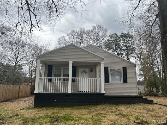 bungalow-style house with a porch and fence